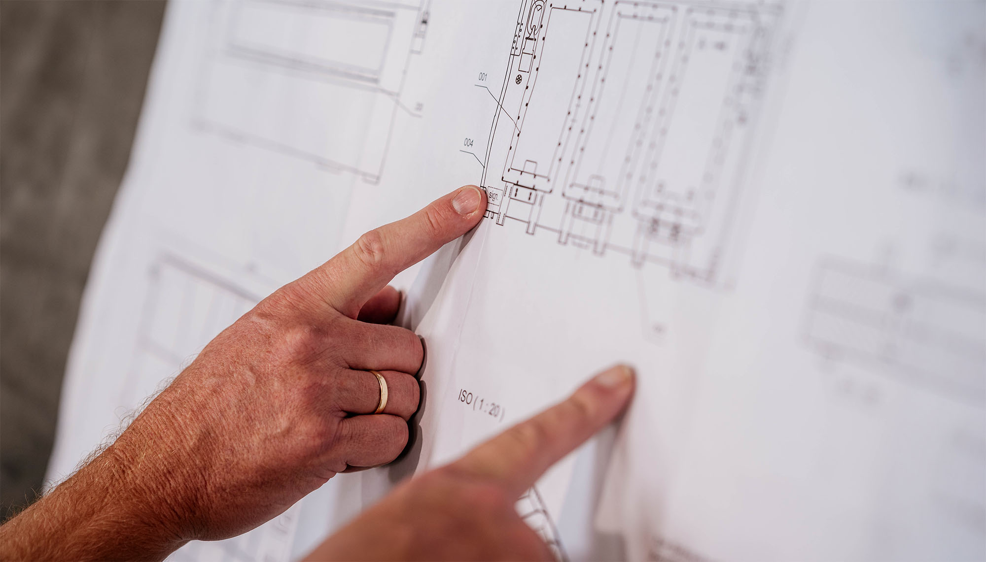 Zwei-Haende-zeigen-auf-einen-Konstruktionsplan-von-RB-Solutions